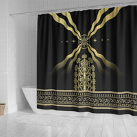 Black shower curtain with gold winged halo emblem, central figure, and patterned hem