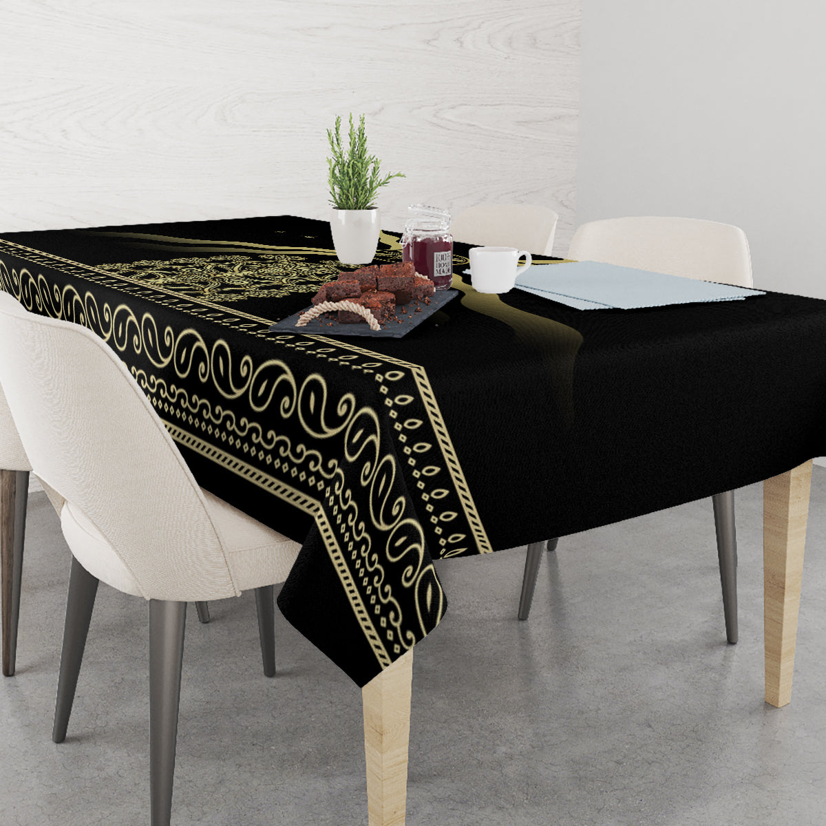 Black tablecloth draped on table with gold band trim and scroll border