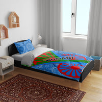 Romani bedding set on a bed: blue mandala duvet with green banner, red wheel, and ROMANI text