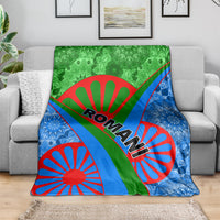 Green, blue, and red Roma pattern blanket draped over a gray sofa arm