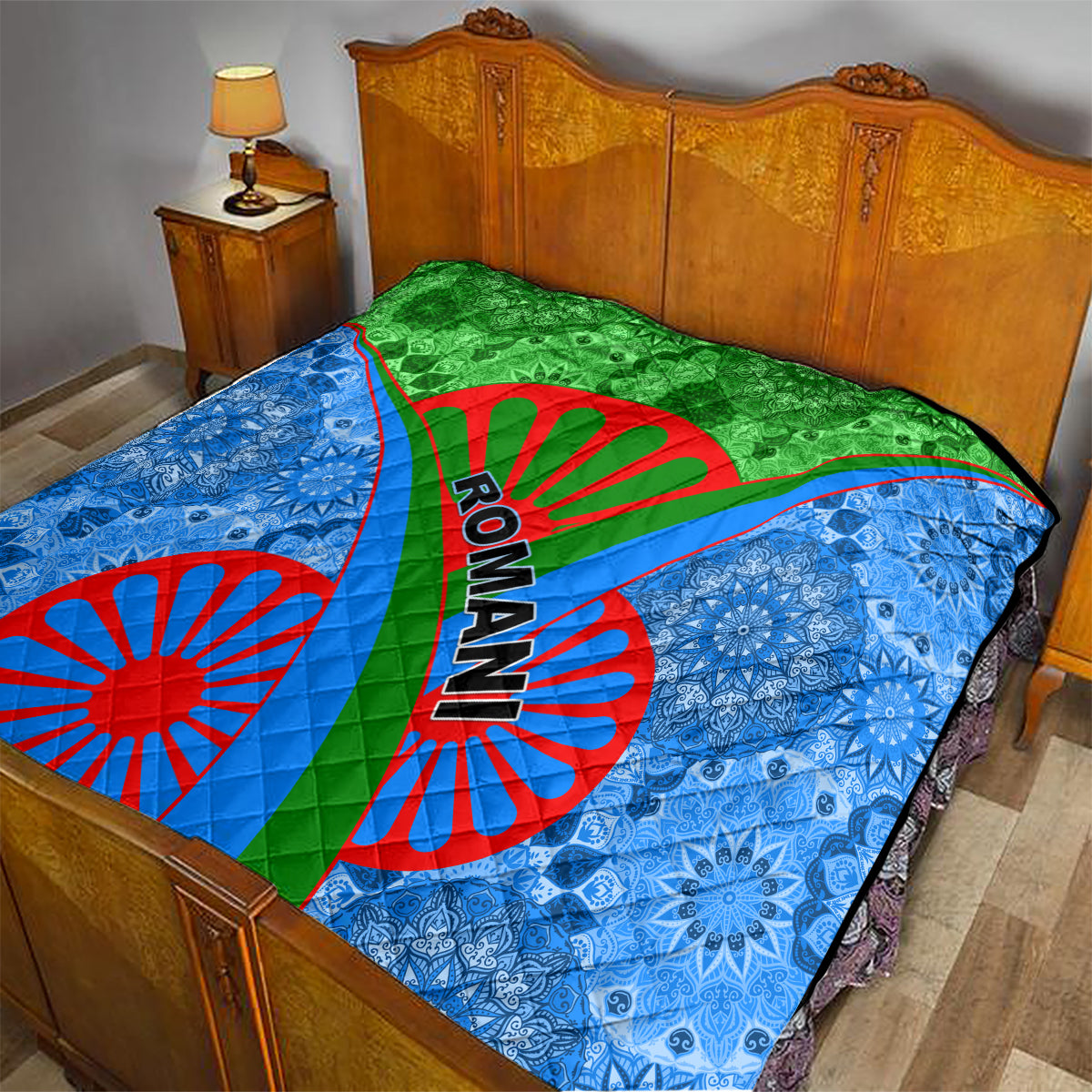 Romani quilt on bed: blue side panels and green center with red wheel graphics and Ro-man text