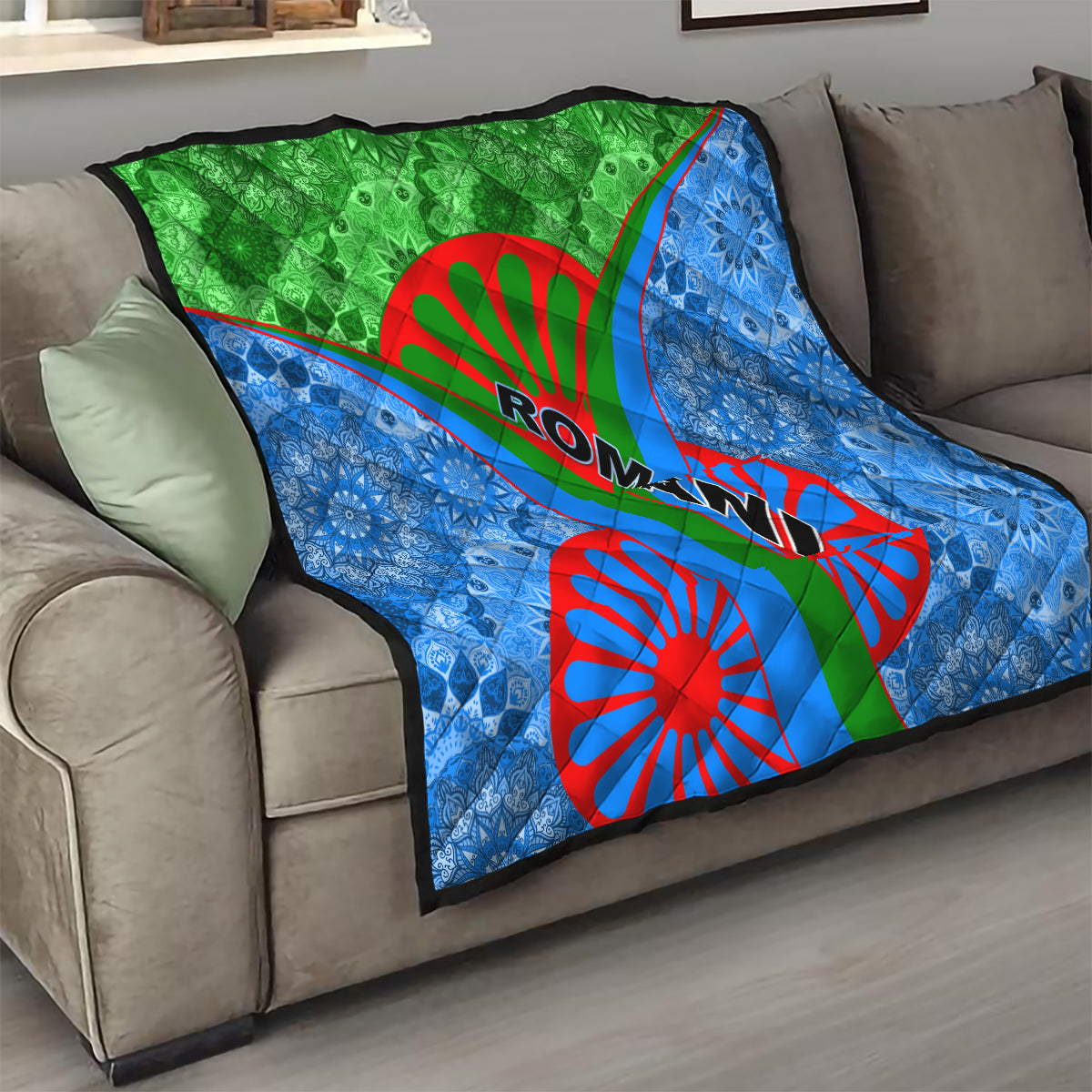 Romani quilt draped on sofa: blue patterned fabric with green center and red wheel and Ro-man text