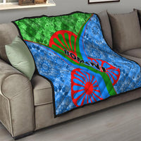 Romani quilt draped on sofa: blue patterned fabric with green center and red wheel and Ro-man text