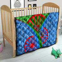 Romani quilt on baby bed: blue patterned panels, green band, red wheel motifs and Ro-man text