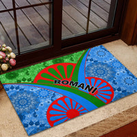 Rectangular rubber doormat on entry steps, blue and green motif with red sunburst arcs and ROMANI