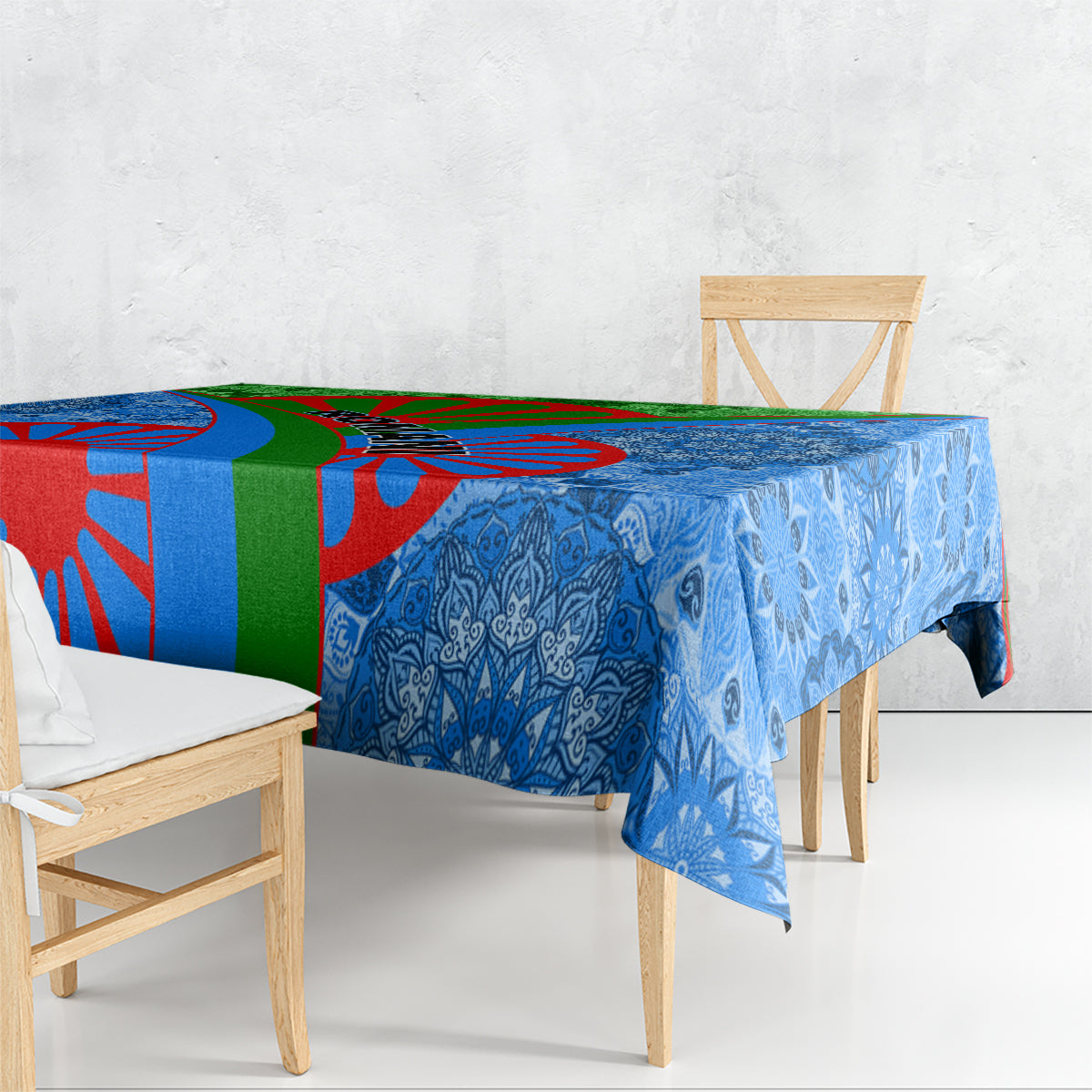 Blue patterned tablecloth draped over a table with matching multicolor border graphic