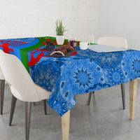 Blue and multicolor tablecloth with ornate floral motifs draped across a dining table
