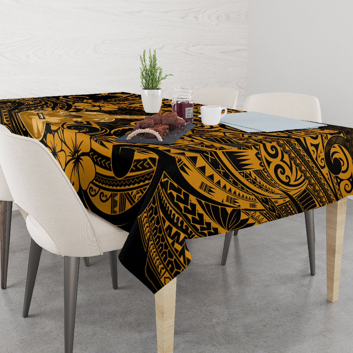 Black and gold polynesian tablecloth with floral and tribal motifs on table