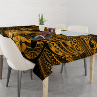 Black and gold polynesian tablecloth with floral and tribal motifs on table