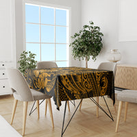 Black and gold polynesian tablecloth covering dining table with matching chairs