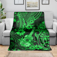 Green ukulele blanket with Polynesian tribal swirls and flower motif, draped on sofa