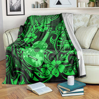 Green ukulele blanket with Polynesian flower and swirl pattern, folded over couch