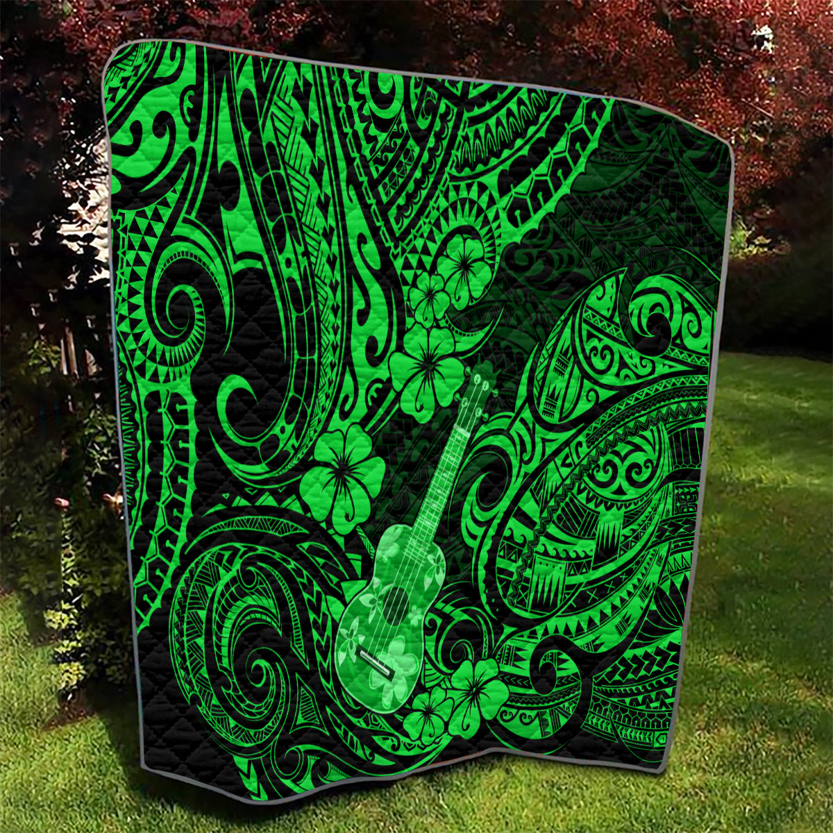 Green Polynesian ukulele and clover quilt blanket with black border, quilted texture