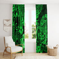 Green Polynesian pattern curtains hanging beside a sofa and basket
