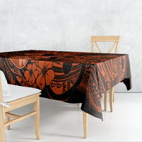 Orange and black Polynesian pattern tablecloth draped on wooden dining table
