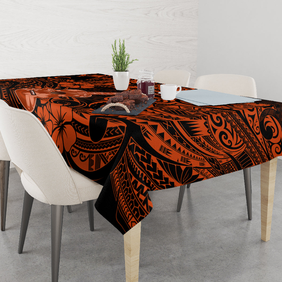 Orange and black Polynesian patterned tablecloth on dining table with chairs