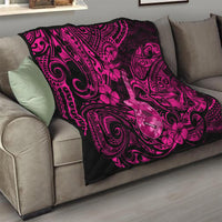 Quilt on gray sofa: pink and dark Polynesian ukulele with floral and swirl motif.