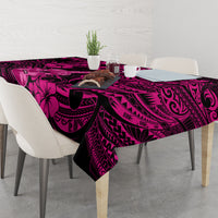 Pink and dark hibiscus and swirl tablecloth covering a dining table, overhanging edges