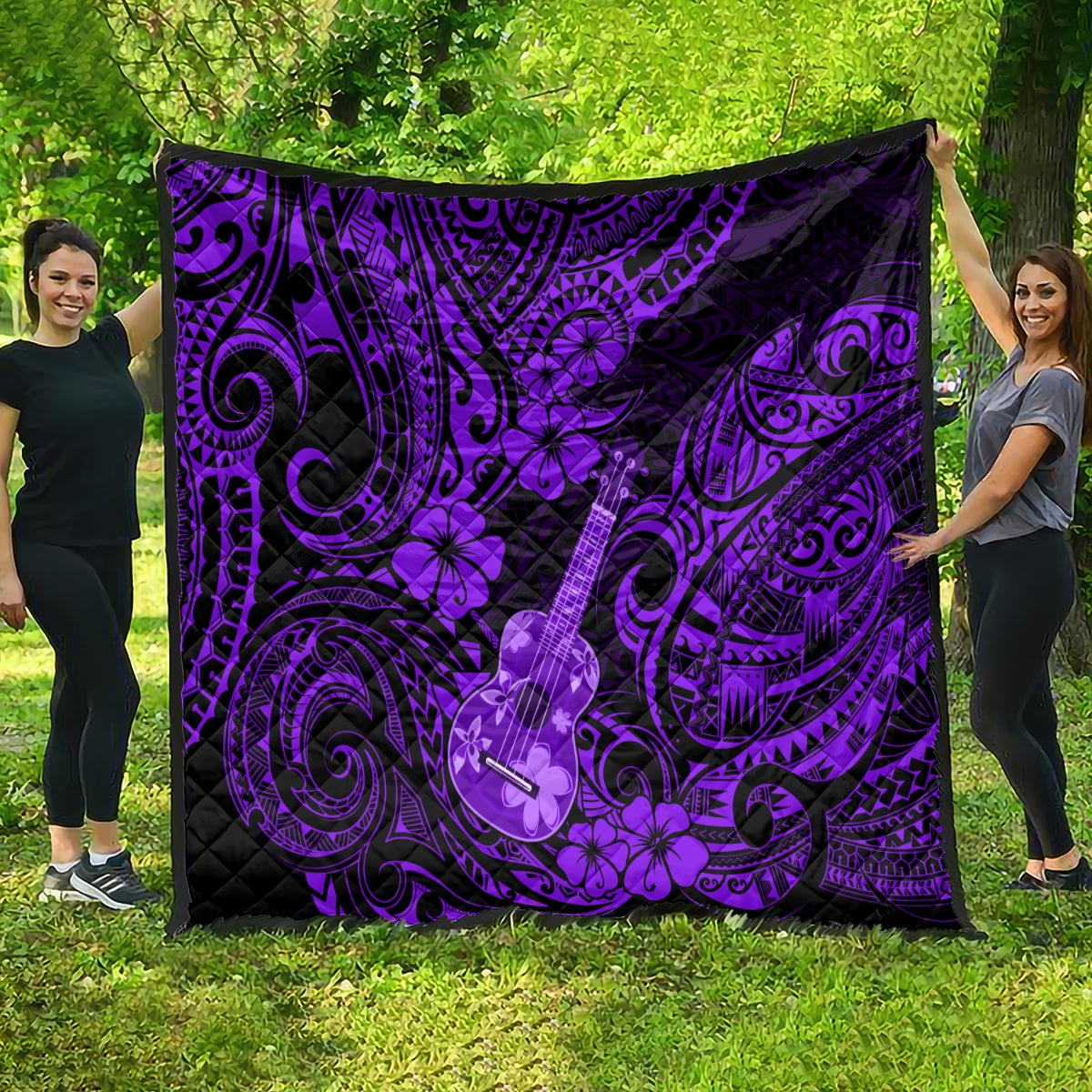 Purple Polynesian ukulele quilt spread on grass, black backing and ornate swirls