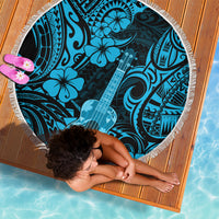 Round beach blanket folded on wood, blue polynesian ukulele print with fringe