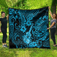 Blue Polynesian ukulele quilt blanket spread outdoors, black backing with swirling tiki pattern