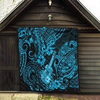 Blue Polynesian ukulele quilt blanket hanging indoors, black backing with turquoise swirl motifs