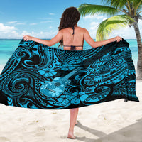 Blue Polynesian sarong with black-and-teal swirls, worn as a wrap
