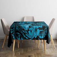Blue Polynesian tablecloth with tiki swirls and hibiscus flowers on dining table