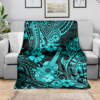 Turquoise Polynesian ukulele blanket spread across a couch with black swirling patterns