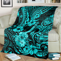 Turquoise and black Polynesian ukulele blanket draped on a sofa with floral motifs