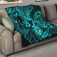 Turquoise Polynesian pattern quilt on a sofa, black edge border with floral ukulele art