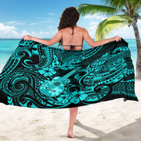 Turquoise polynesian print sarong spread wide, featuring swirling motifs and guitar design