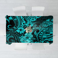 Turquoise Polynesian-style tablecloth with black tiki and floral swirl pattern