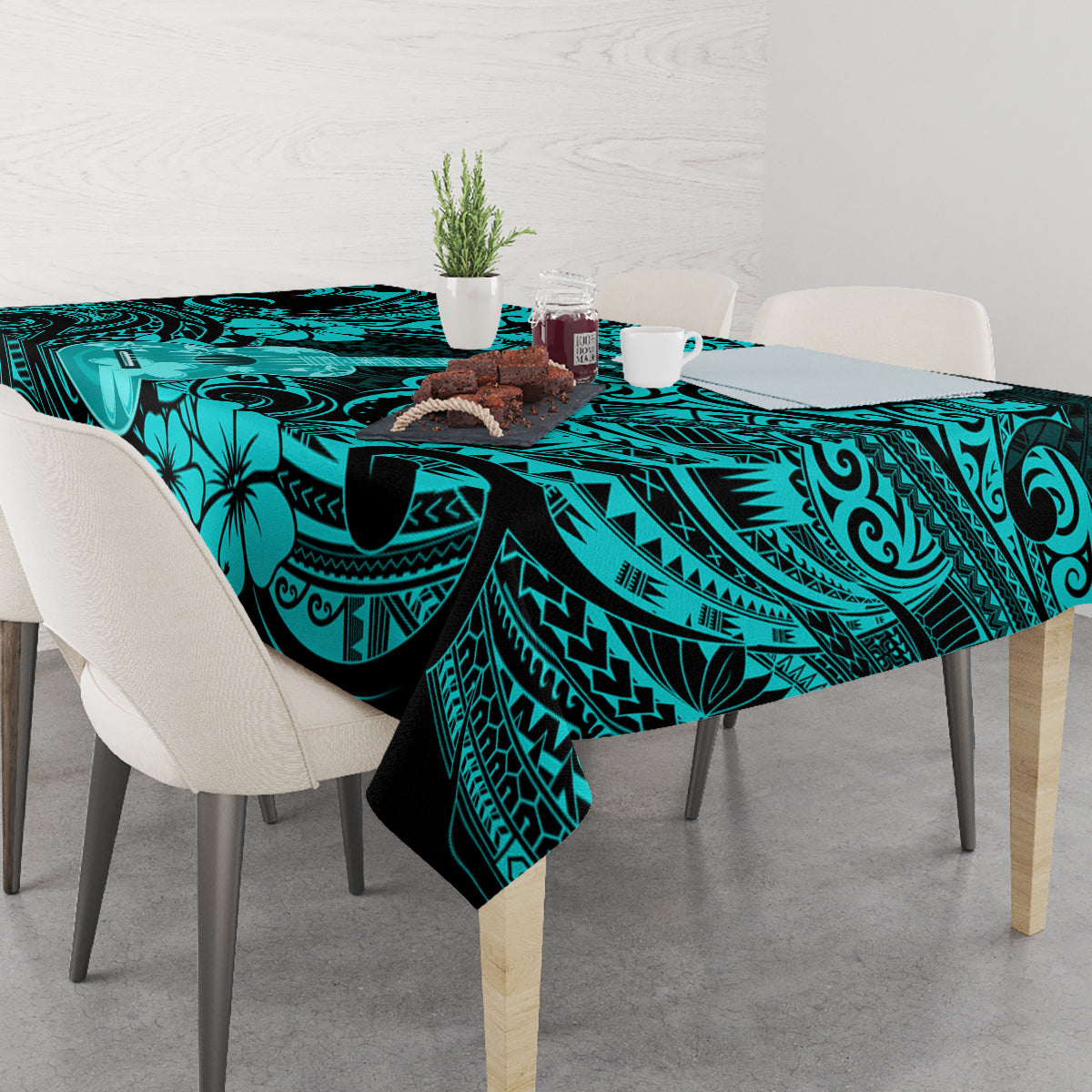 Turquoise tablecloth on dining table with bold black geometric and floral motifs