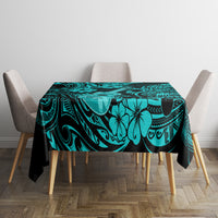Turquoise tablecloth covering dining table with black floral and swirl pattern
