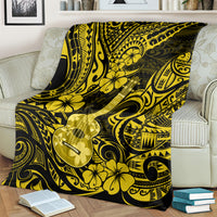 Polynesian ukulele blanket with yellow floral and ukulele motif, draped on couch