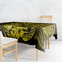 Yellow and black patterned tablecloth draped over rectangular table, scalloped edge