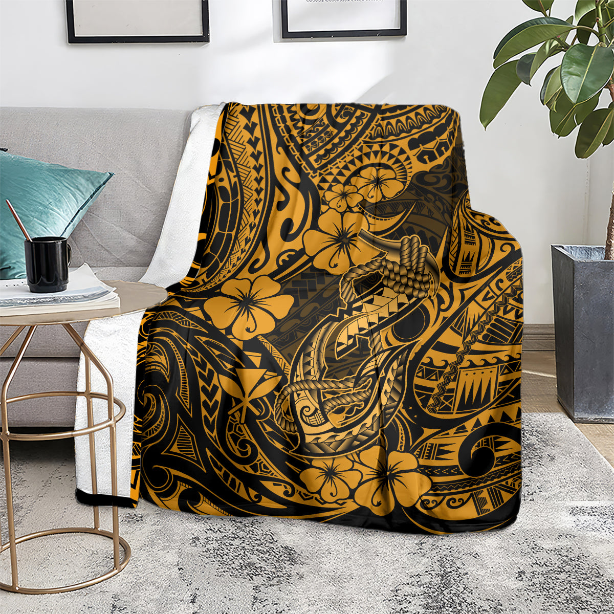 Gold and black Polynesian fish hook throw blanket with floral motifs, draped over seat