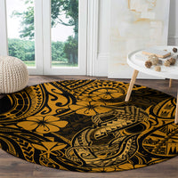 Round gold-and-black Polynesian fish hook patterned carpet on hardwood floor near window.