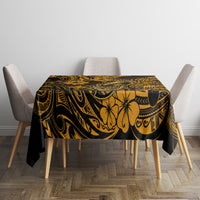 Black tablecloth with gold Polynesian-style floral and swirl pattern on a rectangular tabletop.