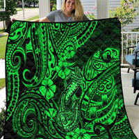 Green Polynesian fish-hook quilt with clover and swirl motifs on black backing