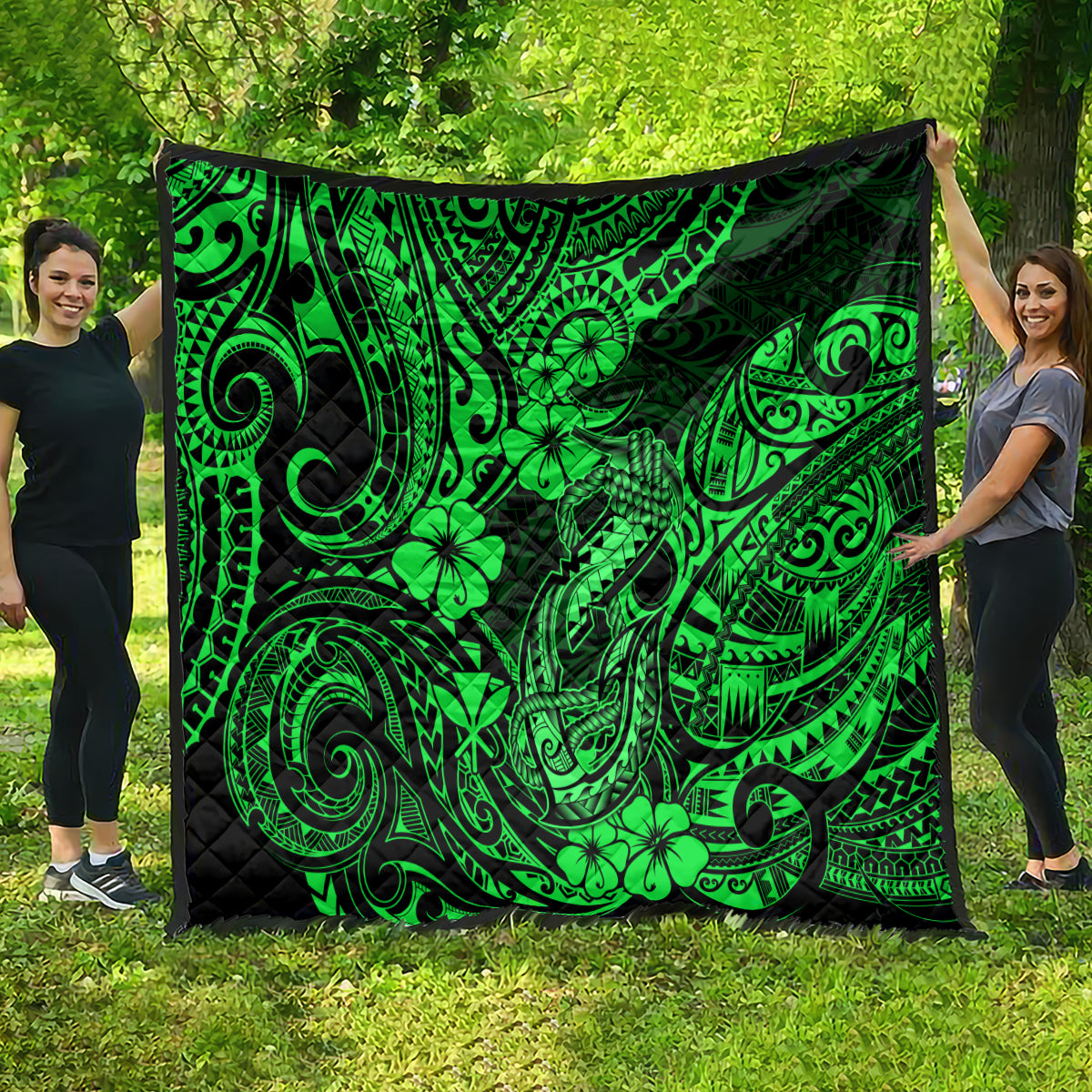 Green Polynesian fish-hook quilt with clover and swirl motifs, spread flat