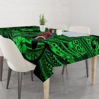 Green Polynesian tablecloth with fish hook and tiki-style graphic motifs, draped
