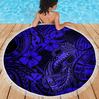 Round navy Polynesian fish hook beach blanket with fringe edge, draped on deck