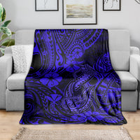 Navy blue fish hook blanket with blue floral and tribal patterns, spread on a sofa