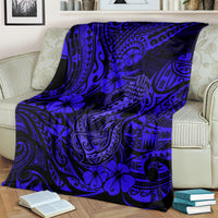 Navy blue blanket with blue fish hook and floral tribal motifs, covering a sofa seat