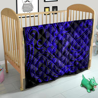 Navy fish-hook quilt blanket on crib with Polynesian swirl pattern