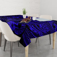 Navy blue tablecloth with Polynesian fish hook pattern over dining table and centerpiece.