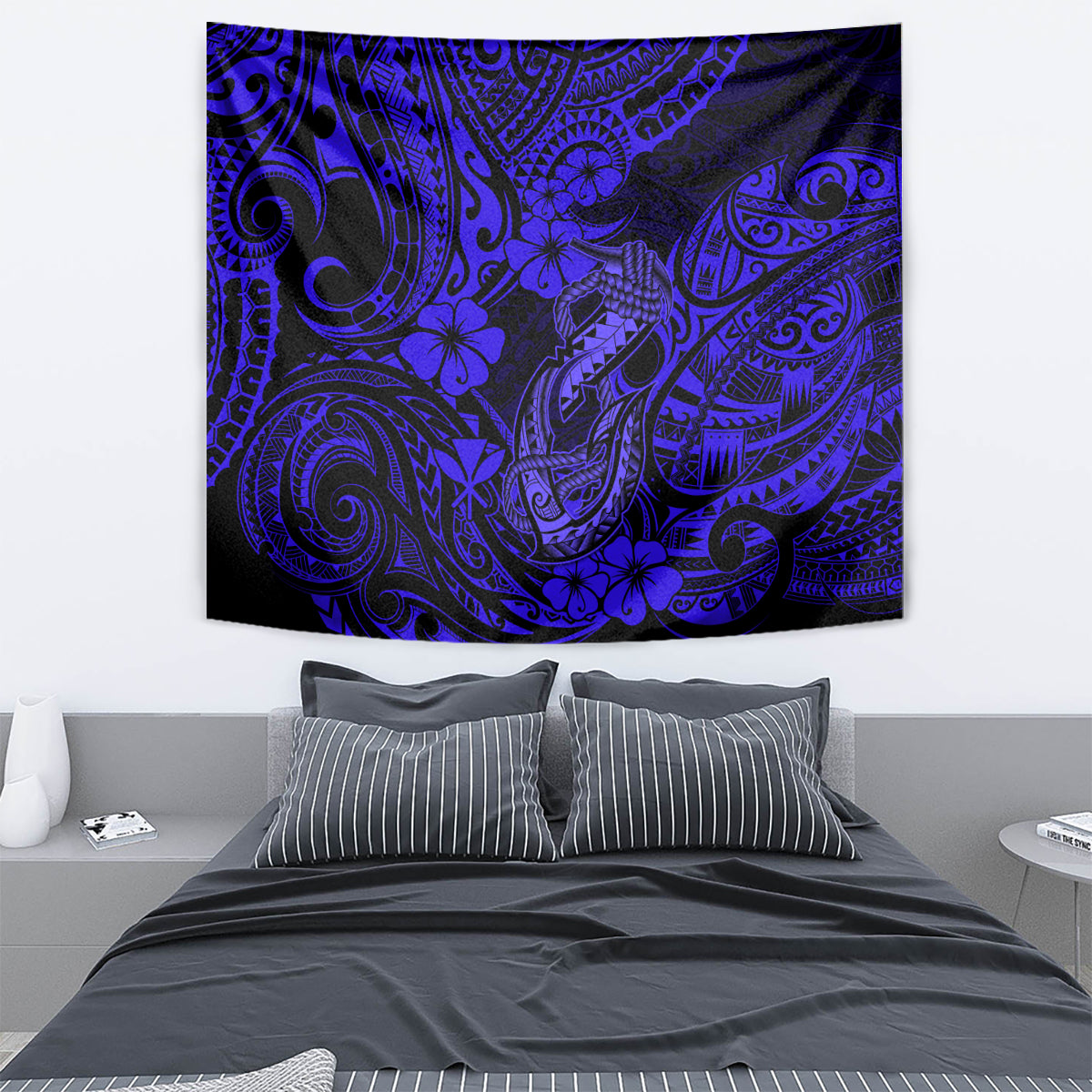 Navy blue Polynesian fish hook tapestry hanging on a wall, with swirling tribal motifs