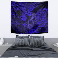 Navy blue Polynesian fish hook tapestry hanging on a wall, with swirling tribal motifs